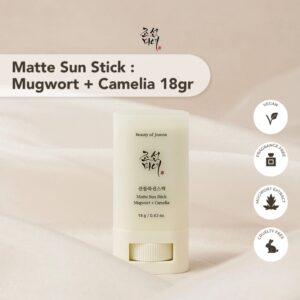 En hvid tube Beauty Of Joseon - Matte Sun Stick: Mugwort + Camilia (18 g) står på en beige overflade med ikoner, der viser den veganske, dyrevenlige og parfumefri formel med beroligende mugwort-ekstrakt.