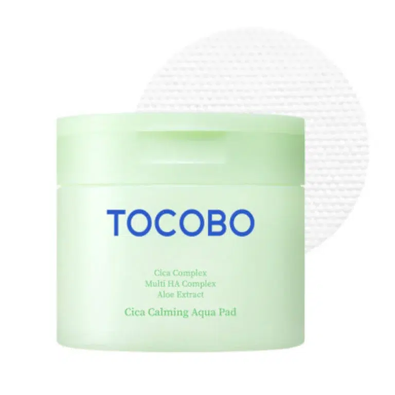 En lysegrøn krukke TOCOBO - Cica Calming Aqua Pad med blå tekst på forsiden og en tekstureret hvid pad i baggrunden.
