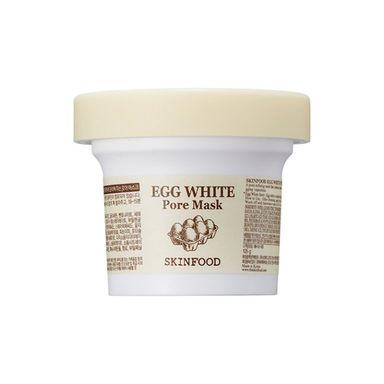 En hvid plastikkrukke med et lysegult låg mærket "Skinfood - Egg White Pore Mask 120g" og dekoreret med brun tekst og æggeillustrationer på forsiden.