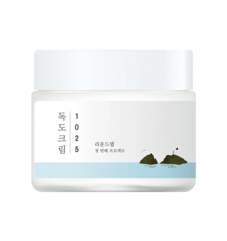 En hvid krukke med et hvidt låg, mærket "Round Lab - 1025 Dokdo Cream" på koreansk og engelsk, viser minimalistisk kunst af to små øer - den ene toppet med et sydkoreansk flag.