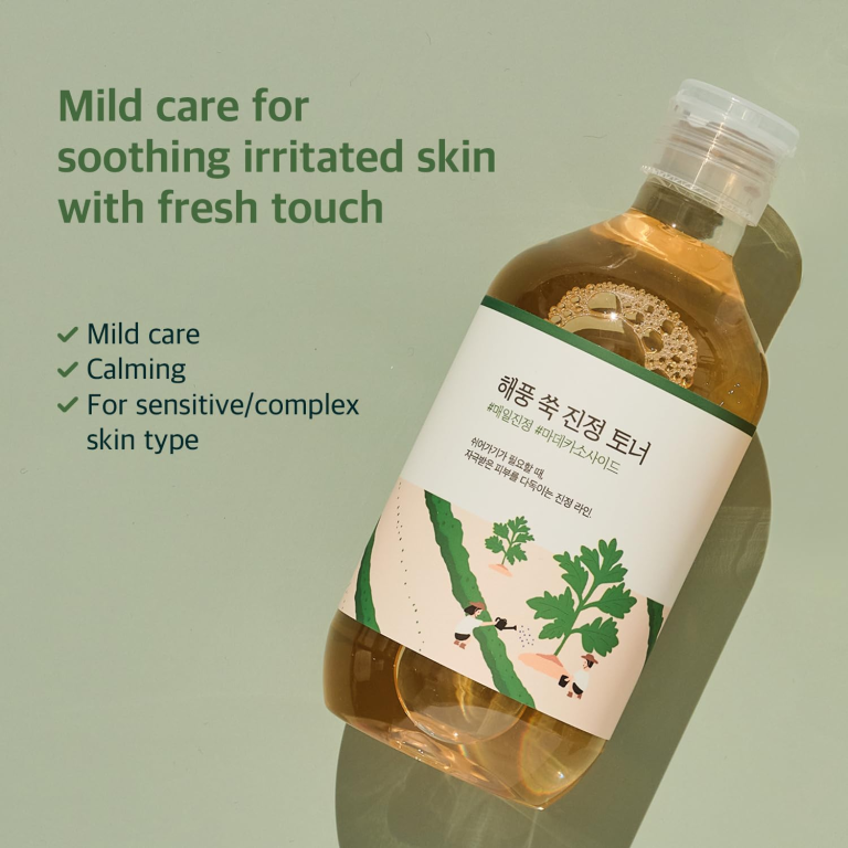 En flaske Round Lab - Mugwort Calming Toner 300ml hviler på en grøn overflade med teksten: "Mild pleje, der beroliger irriteret hud med et frisk touch." Højdepunkter: Mild pleje, beroligende virkninger, velegnet til følsom eller kompleks hud.
