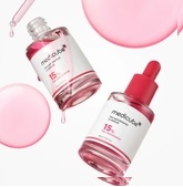 To klare flasker MediCube-serum med pink væske, en med dråbetæller og en åben, er placeret på en hvid overflade med pink dråber og cirkler i baggrunden, hvilket skaber en visuelt tiltalende header-skabelon.
