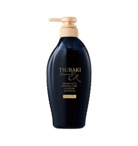 En flaske Shiseido - Tsubaki Premium EX Damage Care & Repair Shampoo med guldpumpe og mørkeblå krop, med guld og hvid tekst på frontetiketten, vises mod en almindelig hvid baggrund.