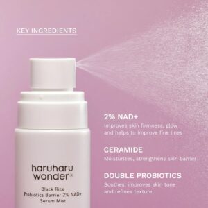 En flaske Haruharu Wonder - Black Rice Probiotics Barrier NAD+ Serum Mist sprøjter mod en pink baggrund med tekst, der fremhæver 2 % NAD+, ceramid og dobbelt probiotika som nøgleingredienser og deres fordele.