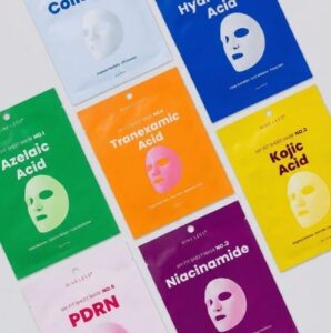 En Nineless - My Fit Sheet Mask No.1 Azelaic Acid-pakke vises på en hvid overflade og fremhæver dens vigtigste hudelskende ingrediens: azelainsyre.