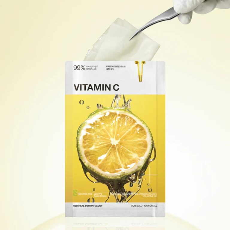 En hånd med handsker bruger en pincet til at tage en Mediheal - Vitamin C Essential Mask Clear Toning ud af en gul og hvid pakke med en citron i skiver og væskedråber på forsiden.