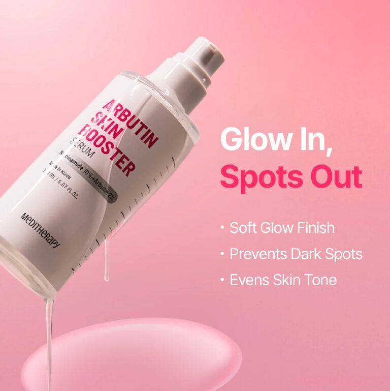 En flaske Meditherapy - Arbutin Skin Booster Serum vipper, mens væsken drypper ud. Tekst: Glød ind, pletter ud. Dette serum giver en blød glød, hjælper med at forebygge mørke pletter og udjævner hudtonen. Lyserød baggrund med en blank dråbe nedenunder.