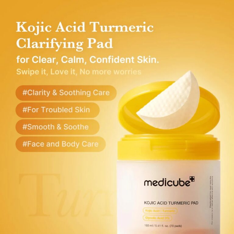 En åben gul beholder med Medicube - Kojic Acid Turmeric Pads afslører en rund pad. Tekst på orange baggrund fremhæver klarhed, beroligende pleje og brug til urolig hud i ansigtet og på kroppen.