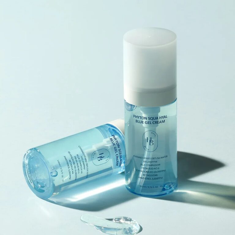 To blå, gennemsigtige flasker med HEVEBLUE - Phyton Squa Hyal Blue Gel Cream vises, en stående og en liggende. En lille mængde gel vises på den lyseblå overflade ved siden af flaskerne.